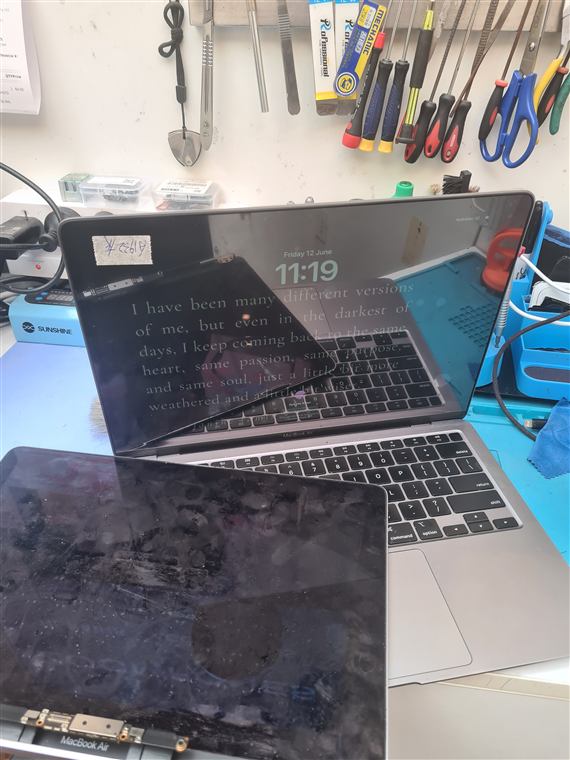 MacBook Air laptops open on the repair bench with tools laid out