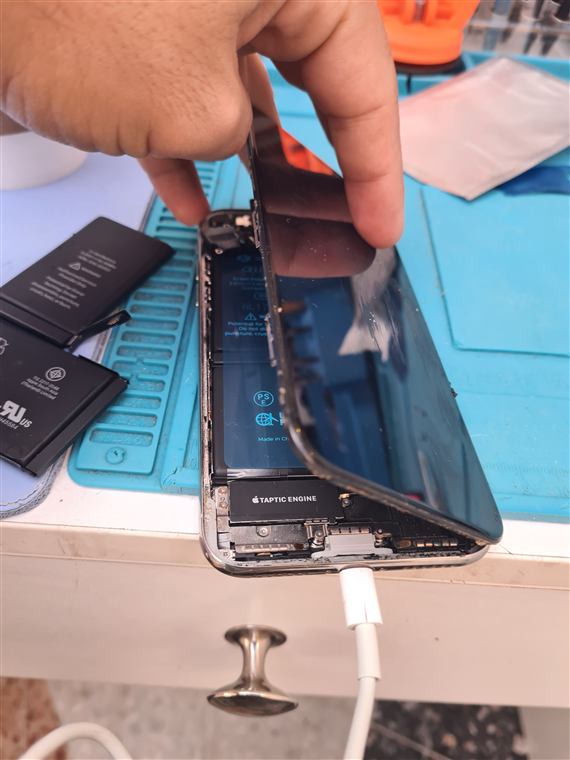 iPhone teardown showing taptic engine and battery during repair