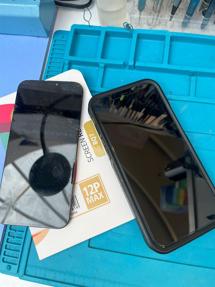 Cracked iPhone 12 Pro Max screen removed from the phone next to the new replacement panel on the CCFix bench