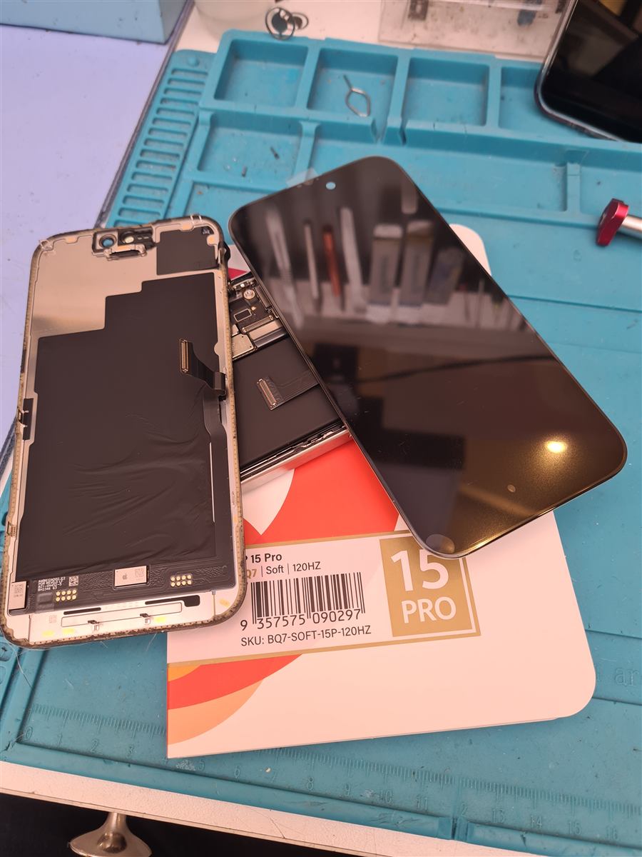 iPhone 15 Pro Soft OLED replacement panel next to the old display on the CCFix bench
