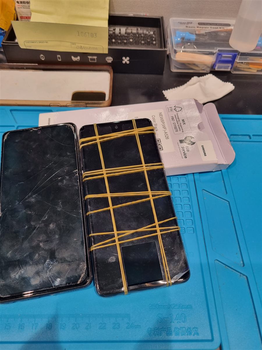 Samsung Galaxy A52 cracked screen next to its replacement display on the CCFix bench